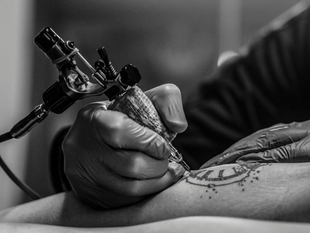 Black and grey tattoo work in progress on an arm