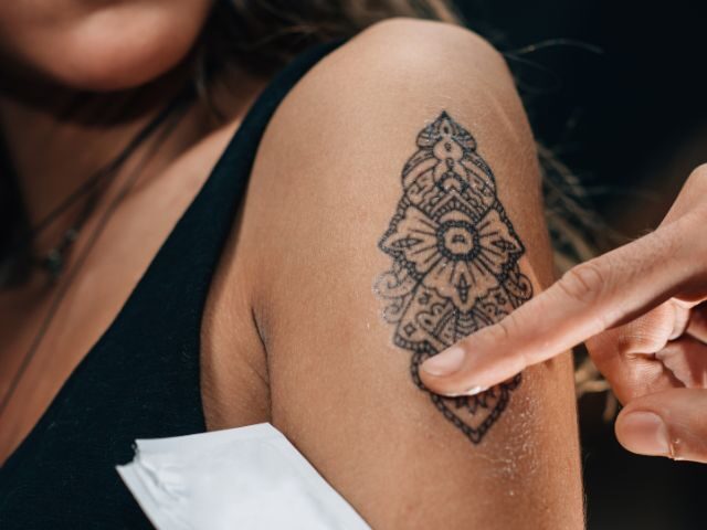 Ornamental tattoo on an upper arm being touched up